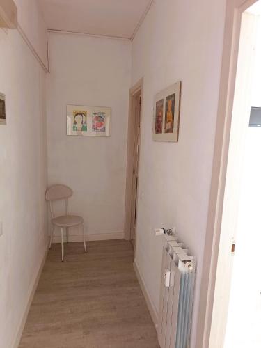 a hallway with a radiator and a chair in a room at Hotel Bacco Rooms and Breakfast in Pietra Ligure