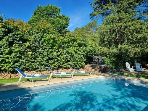 two chairs sitting next to a swimming pool at La Bastide Du Vieux Four Bed&Breakfast in Lorgues