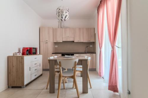 a kitchen with a table and chairs in a room at Le Dune Verdi in Lido di Jesolo