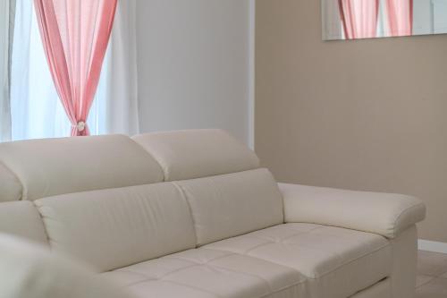 a white couch in a living room with a window at Le Dune Verdi in Lido di Jesolo