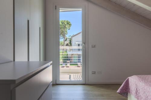a kitchen with a door leading to a balcony at Le Dune Verdi in Lido di Jesolo