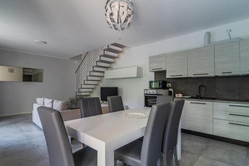 a kitchen and dining room with a white table and chairs at Le Dune Verdi in Lido di Jesolo