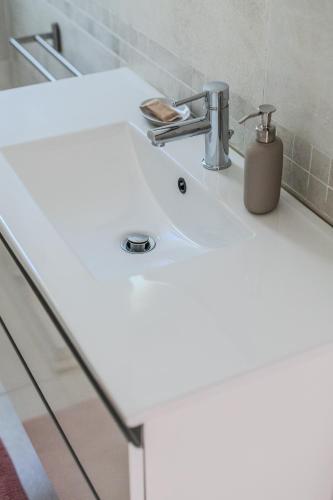 a white bathroom sink with a soap dispenser on it at Le Dune Verdi in Lido di Jesolo