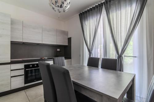 a kitchen with a dining room table and chairs at Le Dune Verdi in Lido di Jesolo