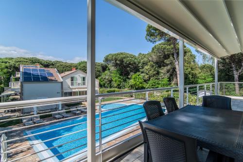 a balcony with a table and chairs and a swimming pool at Le Dune Verdi in Lido di Jesolo