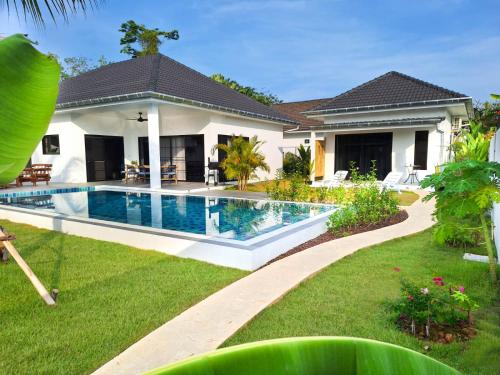 a house with a swimming pool in a yard at Villa et Bungalow Baan Joan Khao Lak in Khao Lak