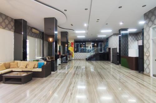 a lobby with a waiting area with couches and tables at RedDoorz Plus Near ICE BSD Minerva in Cilandak