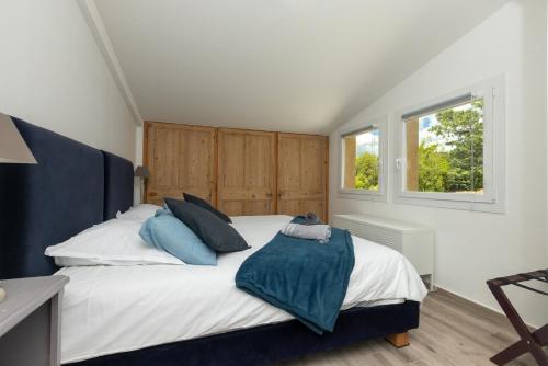 une chambre avec un grand lit blanc avec des oreillers bleus dans l'établissement SmartStay Mas Les Cedres - Proche Isle-sur-la-Sorgue, à Lagnes