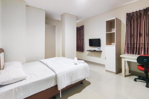 a bedroom with a bed and a desk and a chair at RedDoorz Plus Near ICE BSD Minerva in Cilandak