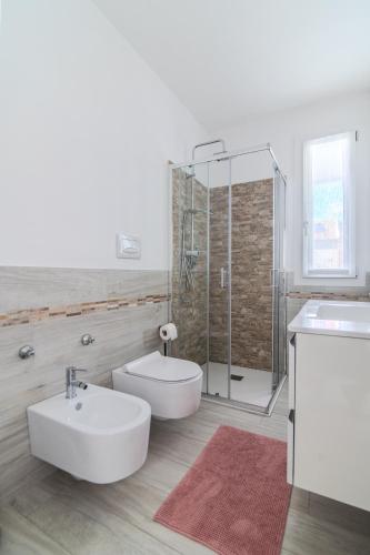 a white bathroom with a sink and a shower at Le Dune Verdi in Lido di Jesolo