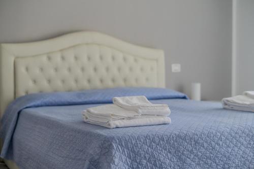 two white towels sitting on top of a blue bed at Le Dune Verdi in Lido di Jesolo