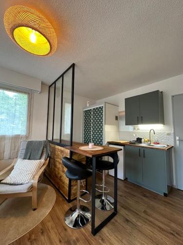 une cuisine avec une table et des chaises dans une pièce dans l'établissement Appart cosy, balcon, parking, à Cherbourg en Cotentin