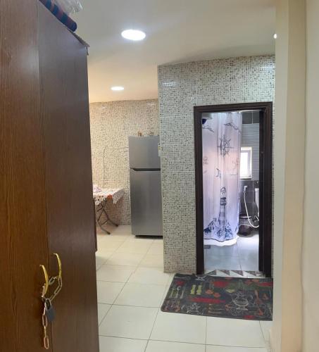 a room with a door and a kitchen with a refrigerator at Al Karak House sharing Apt in Kerak