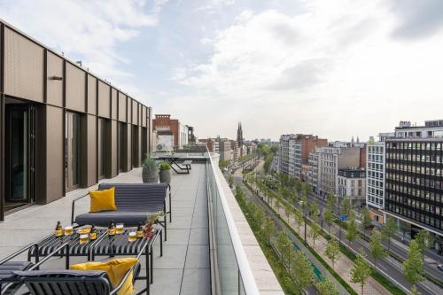 a balcony with chairs and tables on a building at YAYS Antwerp Opera by Numa in Antwerp