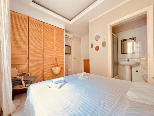 une chambre avec un grand lit blanc et une salle de bain dans l'établissement Le Zen-Appartement 3 Pièces Cannes Centre, à Cannes