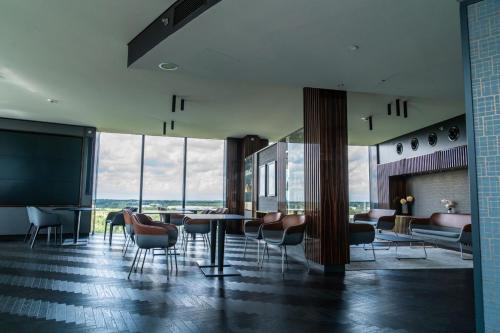 a lobby with chairs and tables in a building at Airport Plaza Hotel Hamburg in Norderstedt