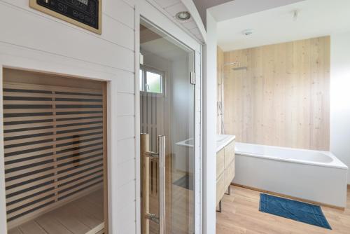 a bathroom with a shower and a tub and a toilet at Le Guillaume - Sauna - A moins de 2 km de la plage in Sainte-Honorine-des-Pertes
