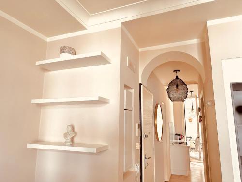 un couloir avec des étagères blanches sur le mur dans l'établissement Le Zen-Appartement 3 Pièces Cannes Centre, à Cannes