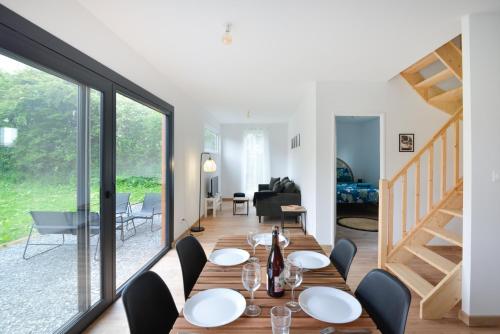 une salle à manger avec une table et des chaises et un escalier dans l'établissement Le Guillaume - Sauna - A moins de 2 km de la plage, à Sainte-Honorine-des-Pertes
