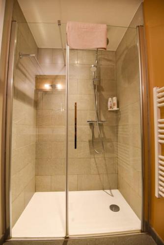 une douche avec une porte vitrée dans une salle de bain dans l'établissement Twin Peaks Lodge - Avoriaz, à Avoriaz
