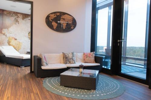a living room with a couch and a coffee table at Airport Plaza Hotel Hamburg in Norderstedt