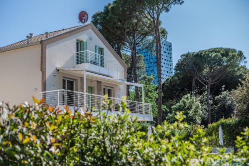 a white house with a balcony on top of it at Le Dune Verdi in Lido di Jesolo