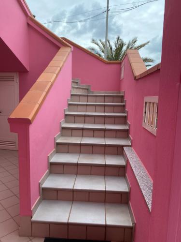 a staircase in a pink house at Nonna Pippi in Oristano