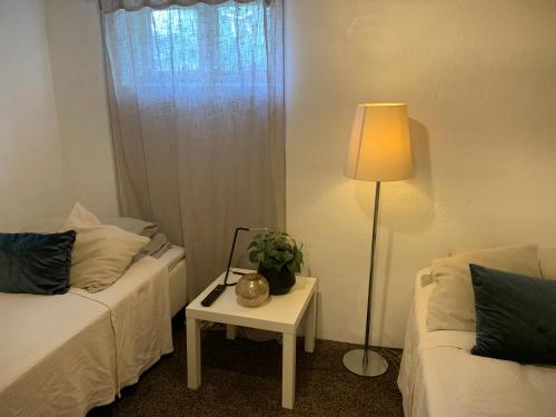 Zimmer mit 2 Betten und einem Tisch mit einer Lampe in der Unterkunft Örgryte centralt in Göteborg