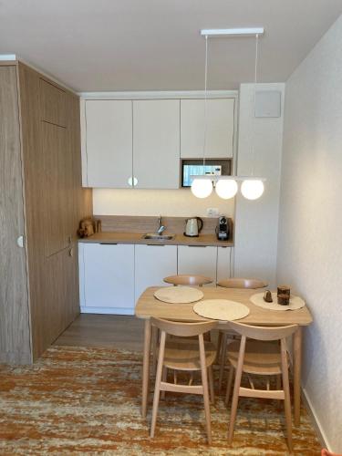 a kitchen with a table and two stools in a room at BEL MARE 2 F207 in Międzyzdroje