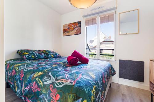 une chambre avec un lit avec une couette colorée et une fenêtre dans l'établissement Duplex & jardin Marché La Baule, à La Baule