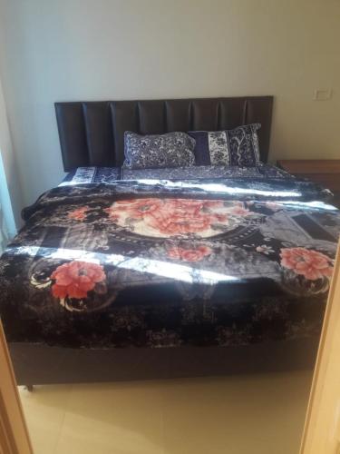 a bedroom with a bed with a floral comforter at Cecil Silver Apartments - Murree in Murree