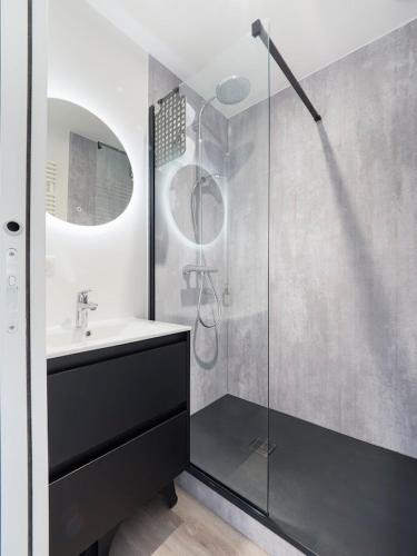 une salle de bain avec un lavabo et une douche en verre dans l'établissement Duplex & jardin Marché La Baule, à La Baule