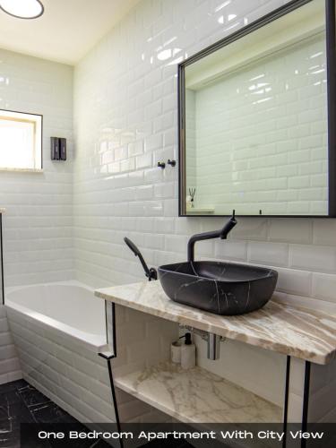 a bathroom with a black sink and a tub at Villa Volos , free private parking in Opatija