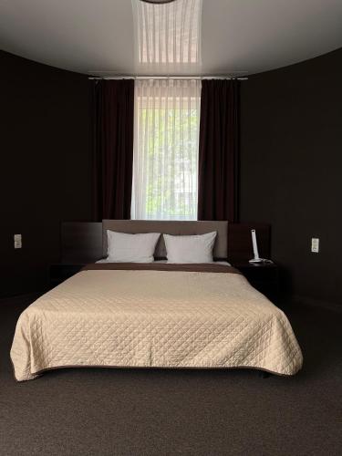 a bedroom with a large bed with a window at Hotel Atmosphere in Poltava