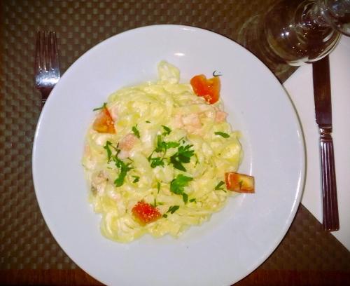 a plate of pasta with shrimp and vegetables on a table at Kyriad Argenteuil in Argenteuil