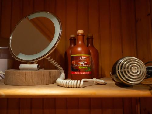 a mirror and a bottle of hot sauce on a shelf at Relax apartma Peter in Ptuj