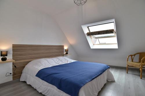 a bedroom with a bed with a blue blanket at Ty Guen Braz - Charmante maison avec jardin in Plurien