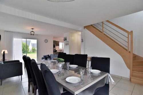 une salle à manger avec une table et des chaises et un escalier dans l'établissement Ty Guen Braz - Charmante maison avec jardin, à Plurien
