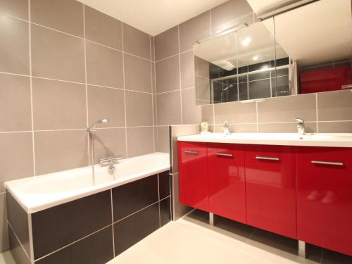 een badkamer met rode kasten, een wastafel en een spiegel bij Gîte Chemillé-en-Anjou-Chemillé-Melay, 3 pièces, 4 personnes - FR-1-622-48 