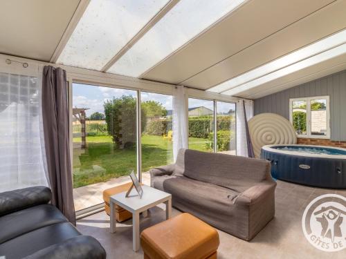 - un salon avec un canapé et une baignoire dans l'établissement Maison spacieuse avec spa, salle de jeux, proche Angers – Idéal familles et pros ! - FR-1-622-59, à Chazé-sur-Argos