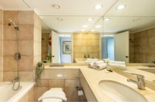 een badkamer met een bad, een toilet en een wastafel bij Almog Tower in Haifa
