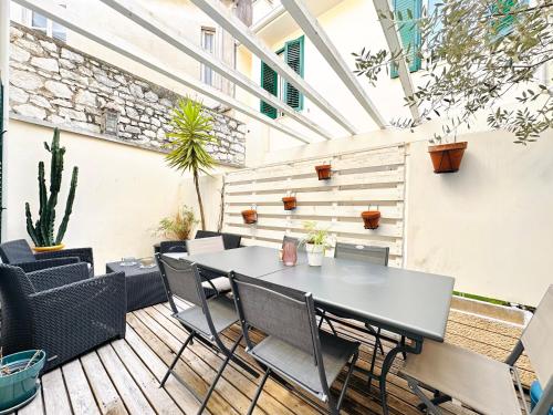 un patio extérieur avec une table et des chaises dans l'établissement Le Zen-Appartement 3 Pièces Cannes Centre, à Cannes