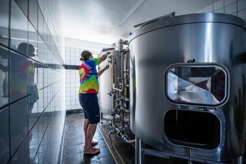 a woman in a tie dyed shirt standing next to a machine at Hotel u Budvaru in České Budějovice