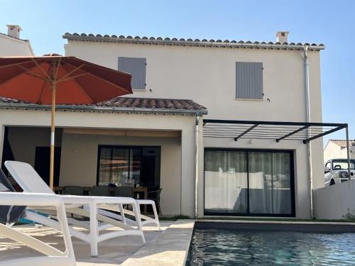 un patio avec des chaises et un parasol ainsi qu'une piscine dans l'établissement Villa Mont Ventoux, à Malaucène
