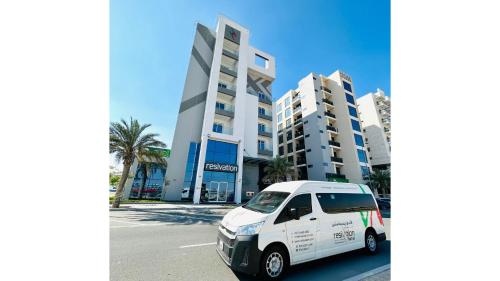 a white car parked in front of a building at Resivation Hotel in Dubai
