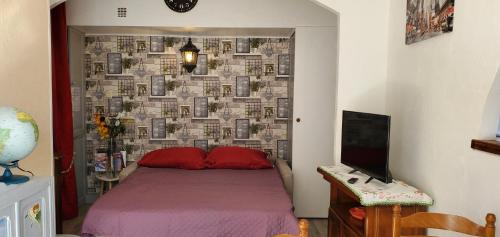 - une chambre avec un lit et un mur avec des photos dans l'établissement vadon geneletti, à Fréjus