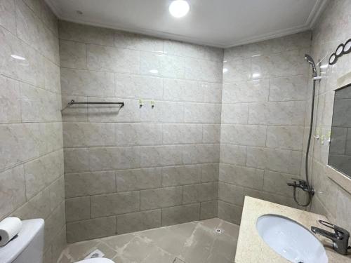 a bathroom with a sink and a toilet and a shower at Al Hayat Suites Apartment in Manama