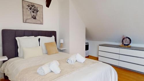 une chambre avec un grand lit avec des serviettes dessus dans l'établissement Triplex Le Bel Âtre, à Sélestat