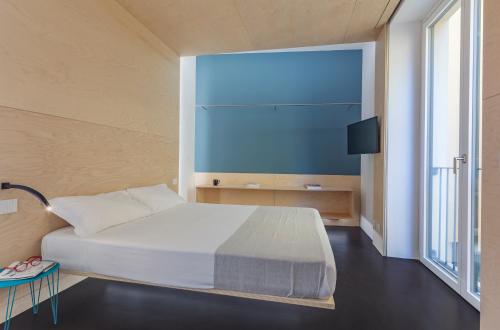 a bedroom with a bed and a flat screen tv at Fiveplace Design Suites & Apartments in Trapani