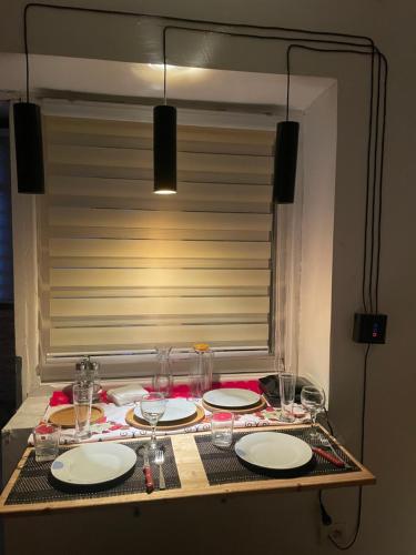 a table with plates and wine glasses on it at Juliette apt with private garden in Korçë